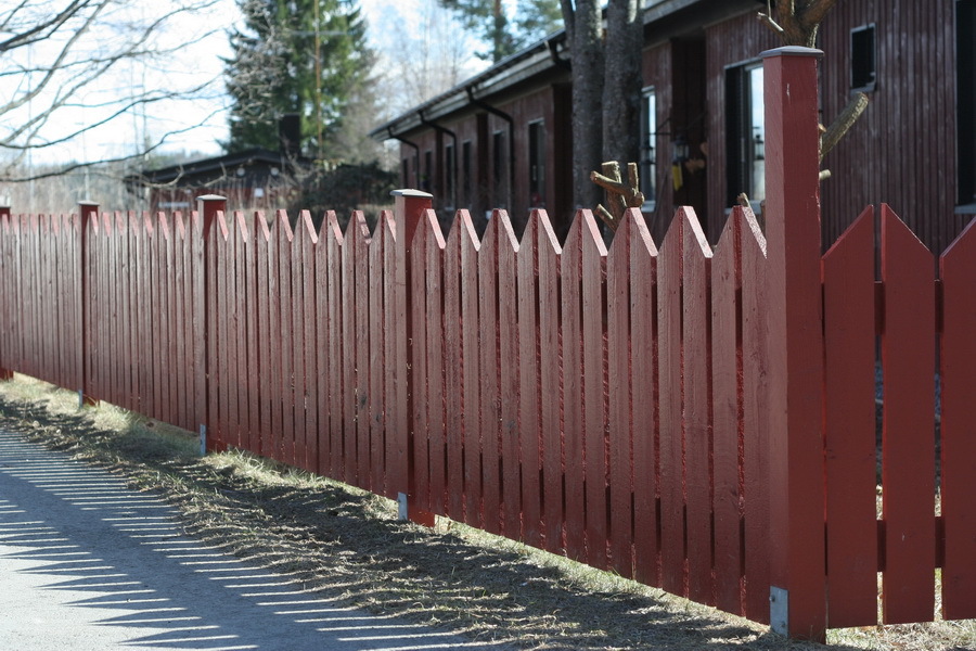 Malet hegn lavet af træplader ved deres sommerhus