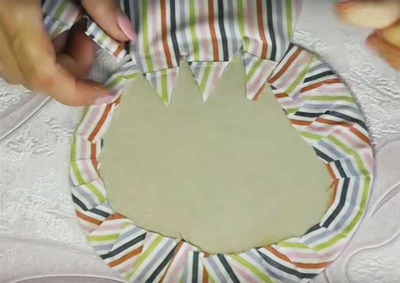 Schneiden Sie einen Kreis aus Pappe, der gerade in das Glas passt, und wickeln Sie ihn in ein Tuch ein