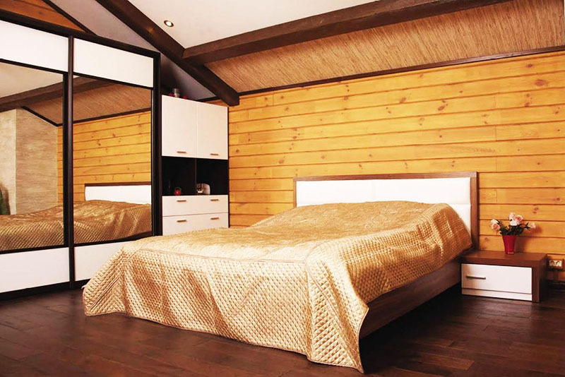Australier verwenden oft Holz, um die Wände im Schlafzimmer zu dekorieren - dies verleiht dem Raum eine warme und gemütliche Atmosphäre.