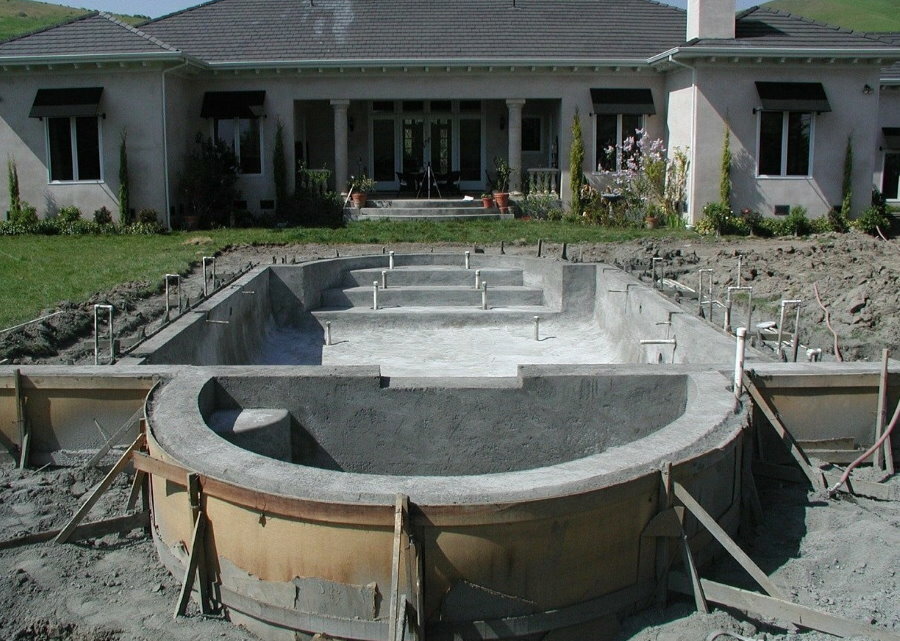 Construcción de una piscina de hormigón en una zona suburbana.