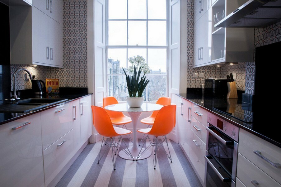 Orangefarbene Stühle in einer schmalen Parallelküche