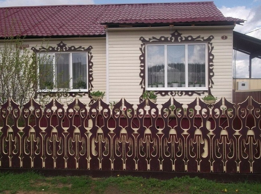Předzahrádka venkovského domu s vyřezávaným plotem