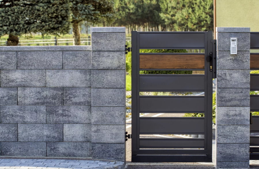 Metal gate in a concrete block-type fence