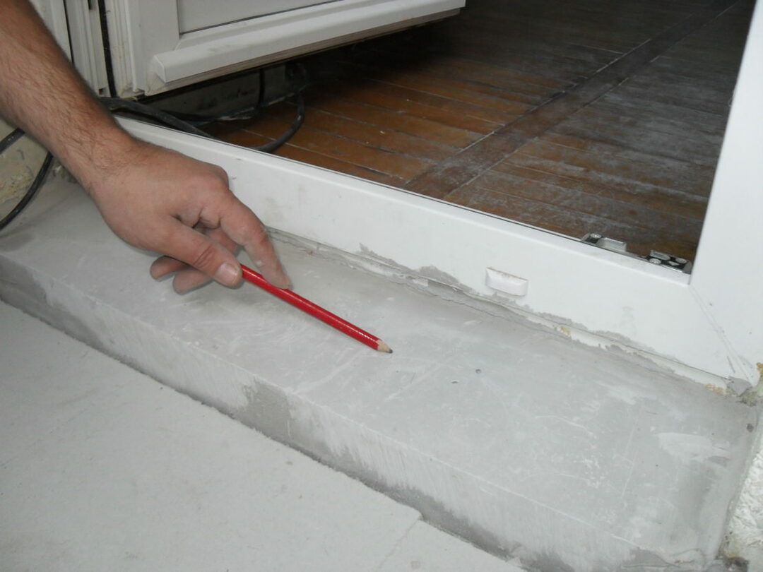 Limite de cimento em frente a uma porta de plástico na varanda