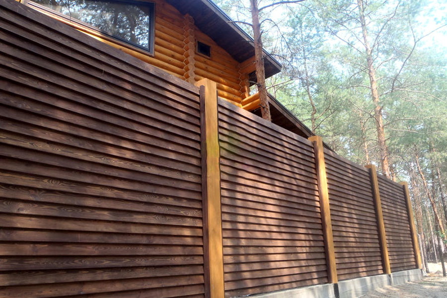 Pevný plot z dřevěných žaluzií na jejich letní chatě