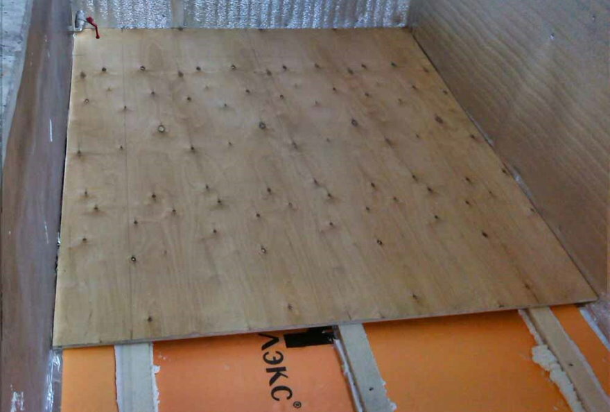 Instalación de madera contrachapada en el piso de un balcón cálido.