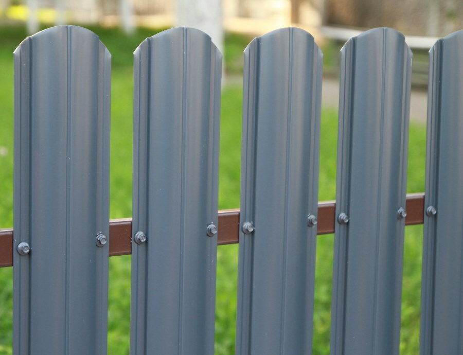 Staccionata grigia su una recinzione metallica