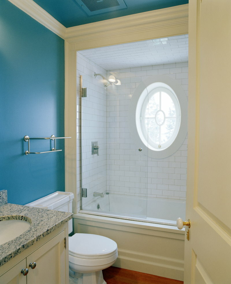 Ovales Fenster über der eingebauten Badewanne