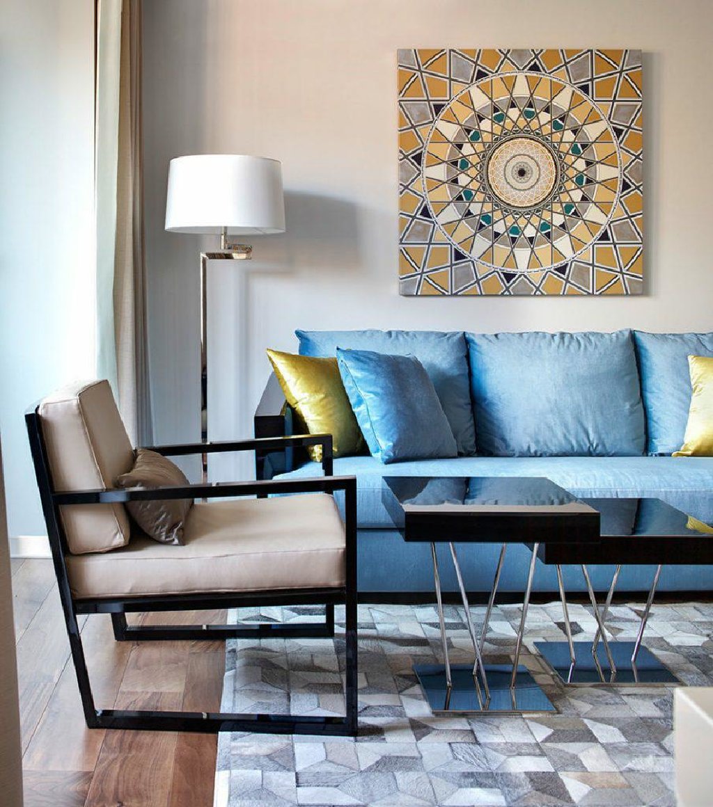 Quadro quadrato su un divano blu in un appartamento