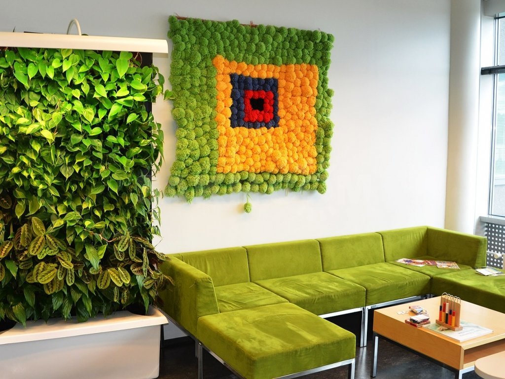Obývacia stena v miestnosti so zelenou pohovkou